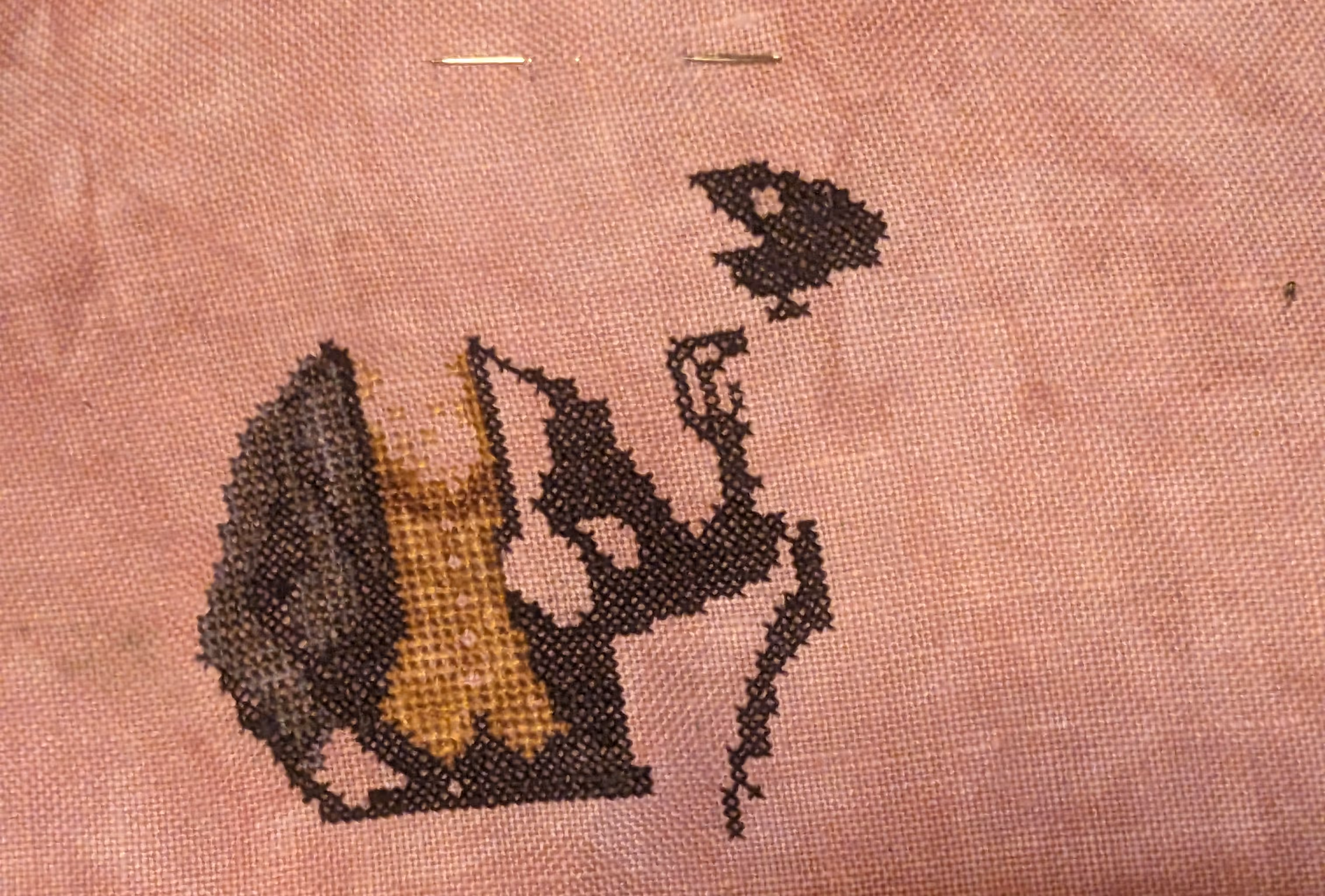 A cross stitch of a crow couple strolling through a graveyard under the moonlight
