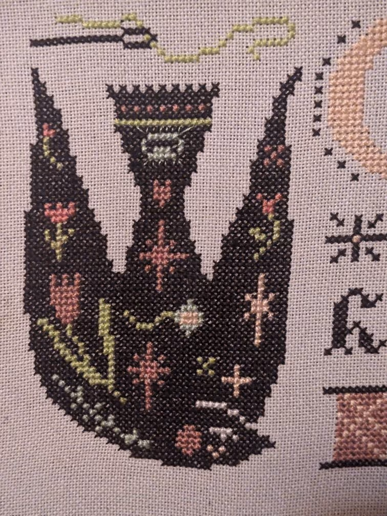 A black bird covered in floral blooms looks to to the right