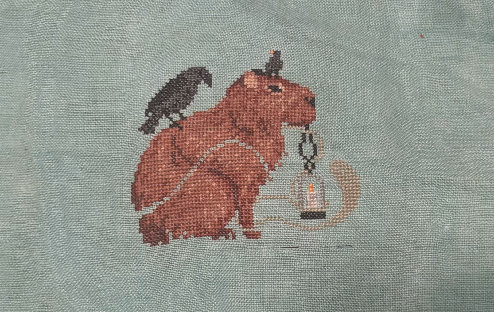 A capybara hangs out with some black birds while carrying a light and visiting with ghosts