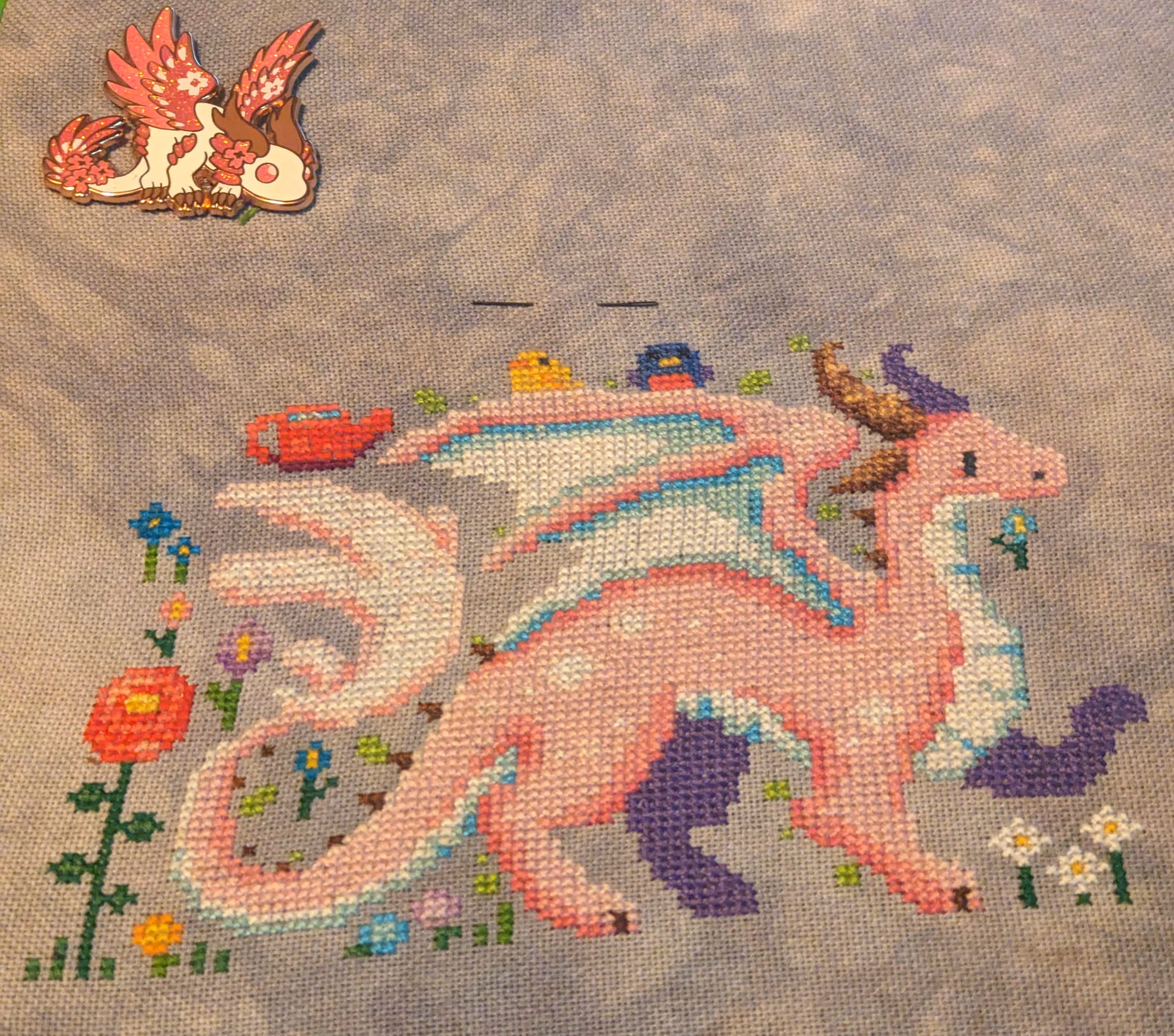 image of a cherry blossom dragon in pink and white in a green meadow with flowers, grass, and birds