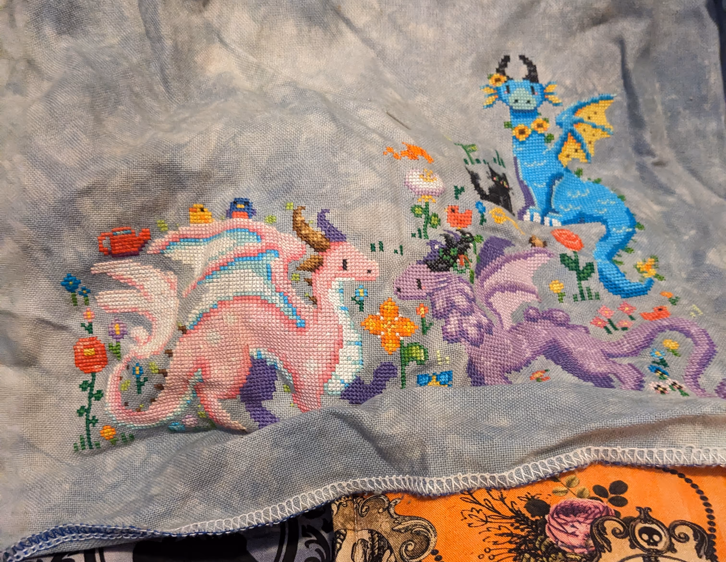 Three floral inspired dragons frolic in a meadow in the colors of a cherry blossom, a wisteria, and a sunflower