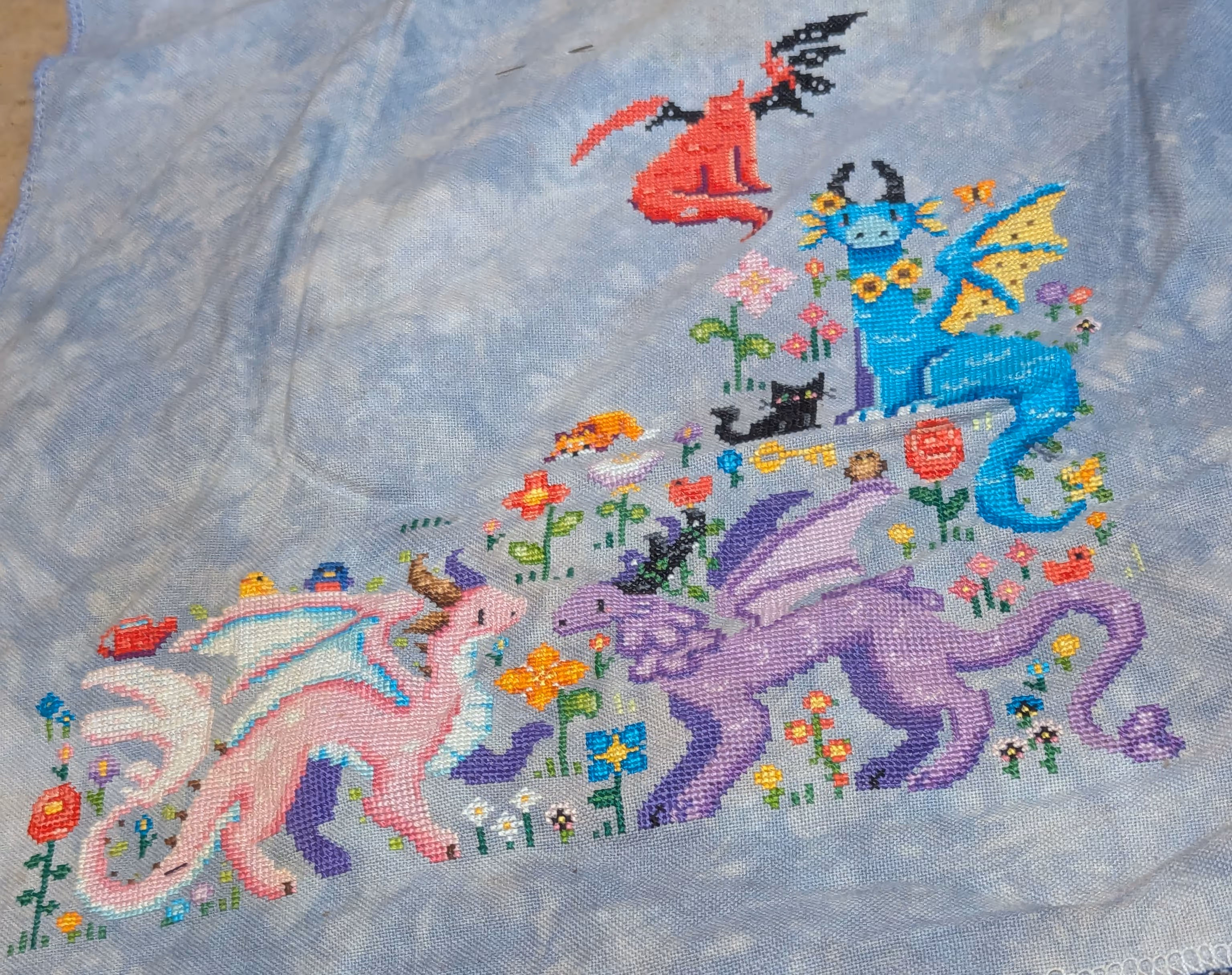 A pink cherry blossomed dragon and a purple wisteria dragon are in a meadow with flowers and birds.