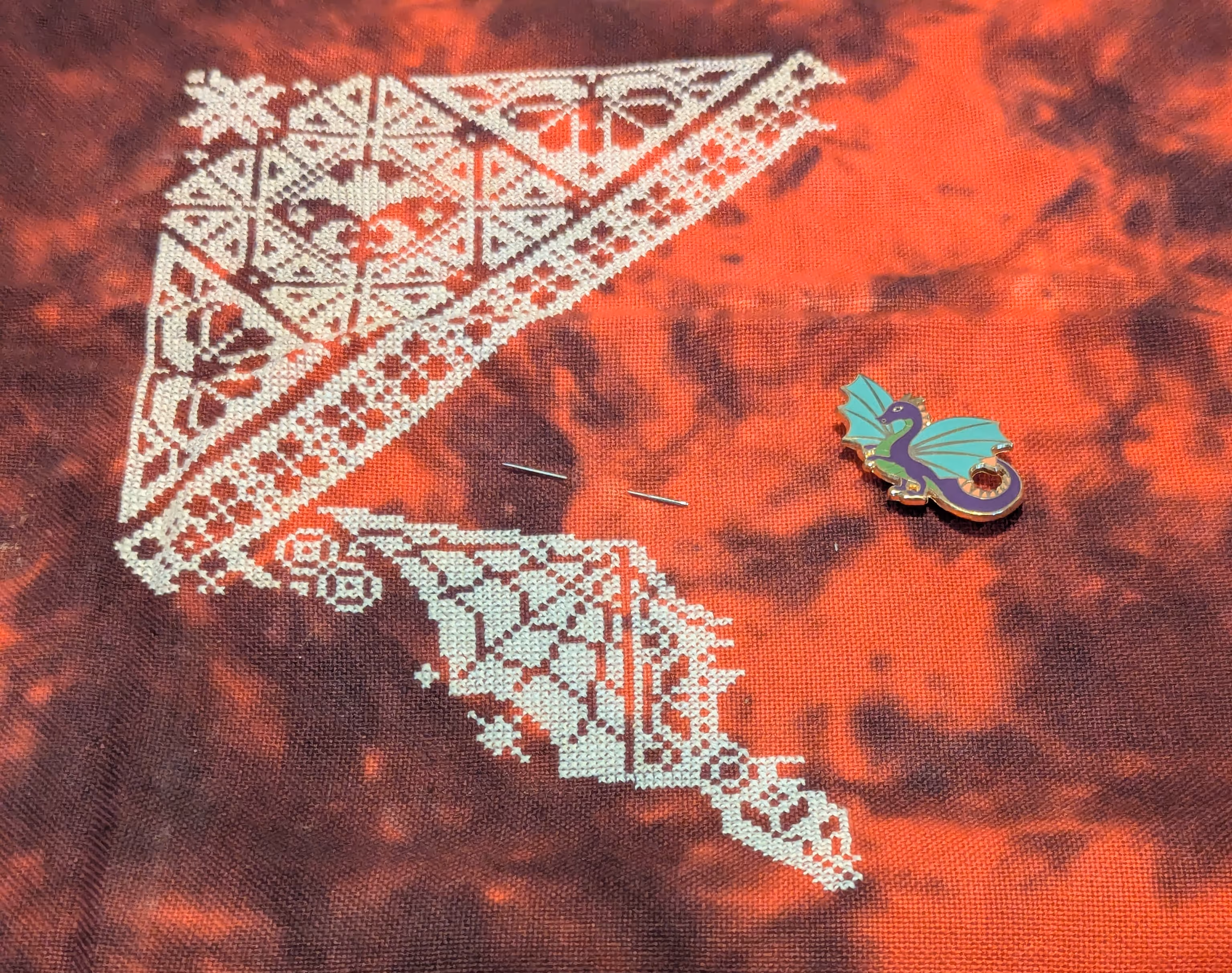 A geometric and repeating design in white thread featuring bats.