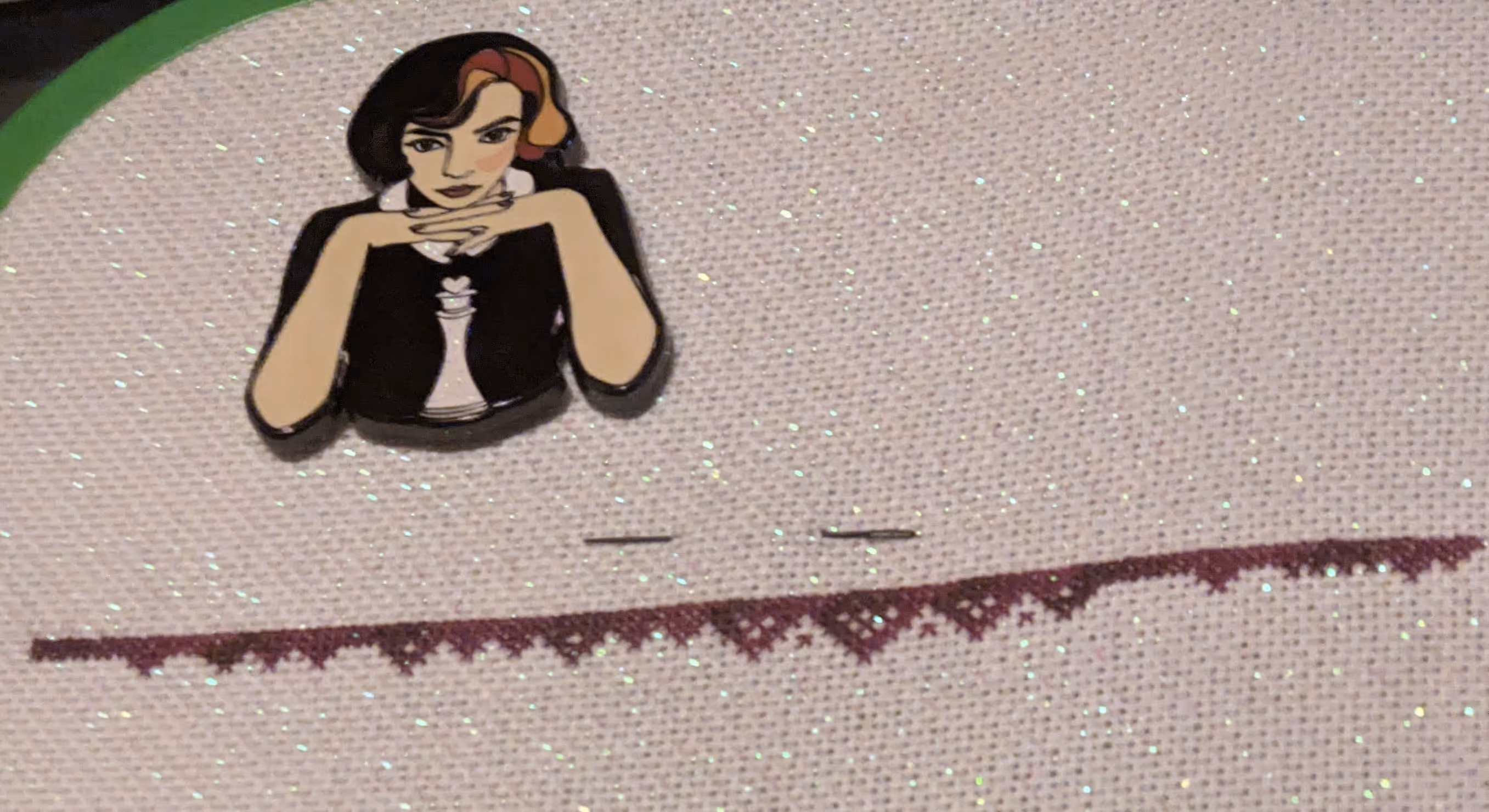 image of a border in red variegated silk thread on white opalescent fabric