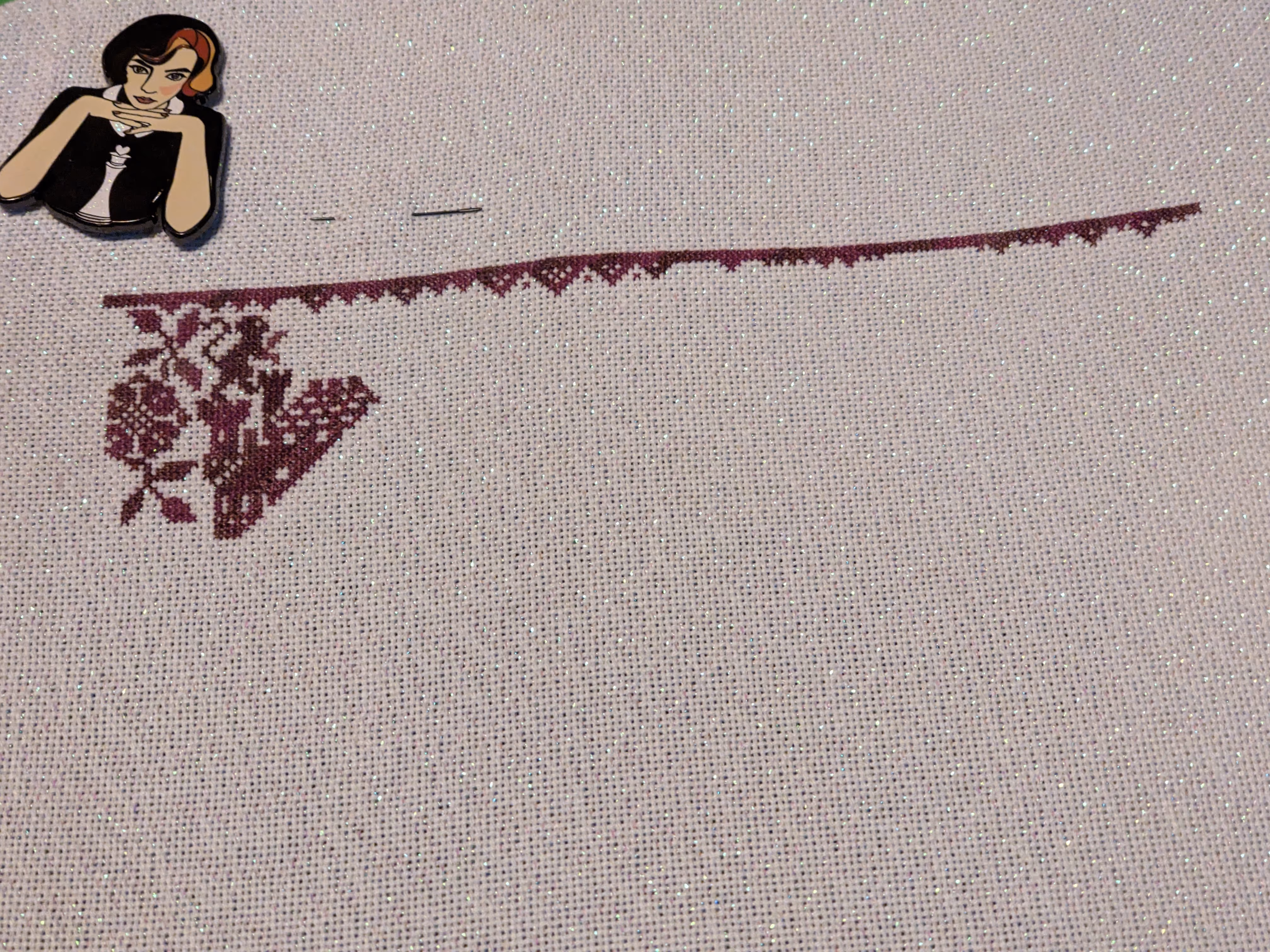 A cross stitch sampler in progress featuring a castle