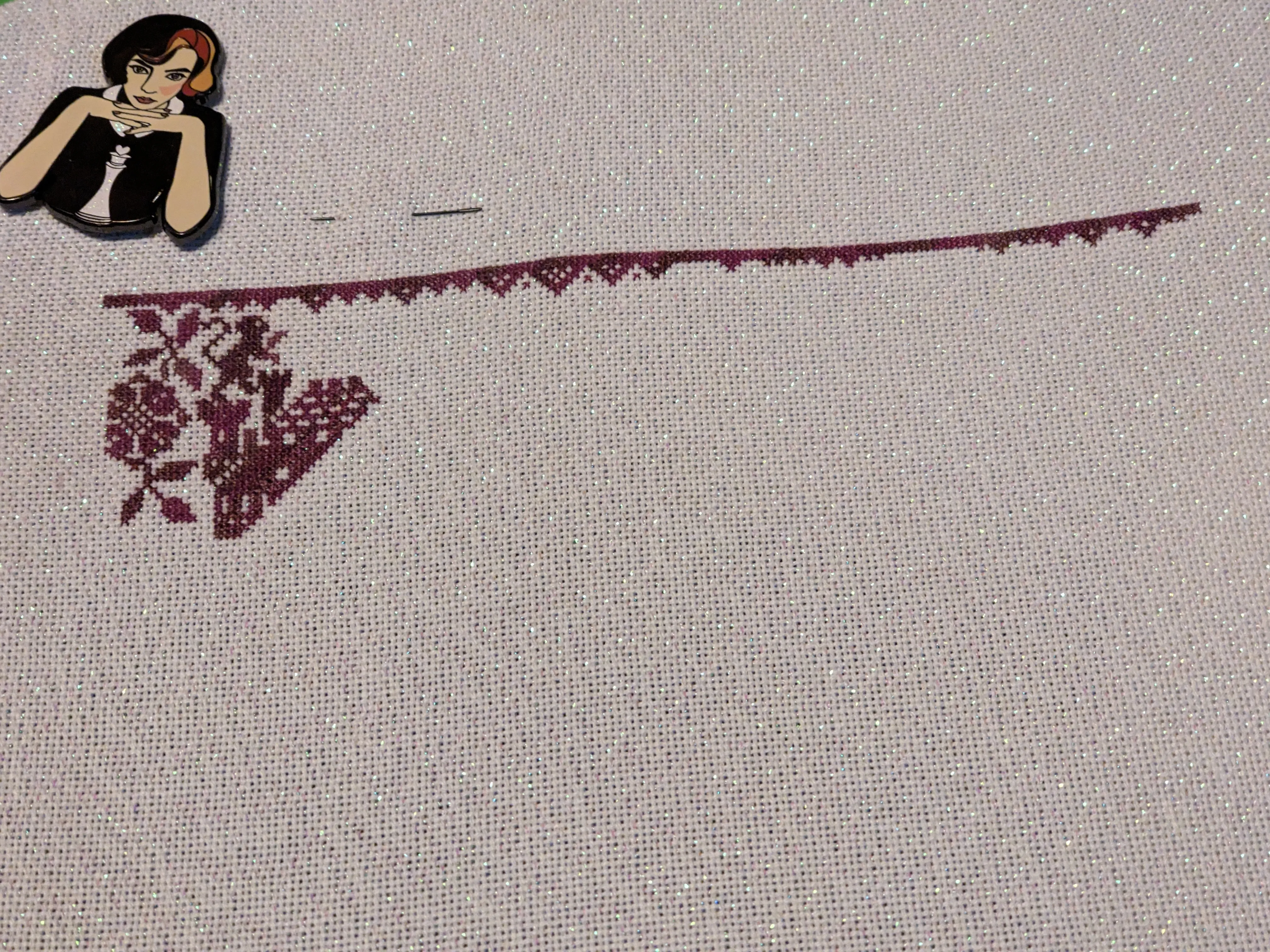A cross stitch sampler in progress featuring a castle