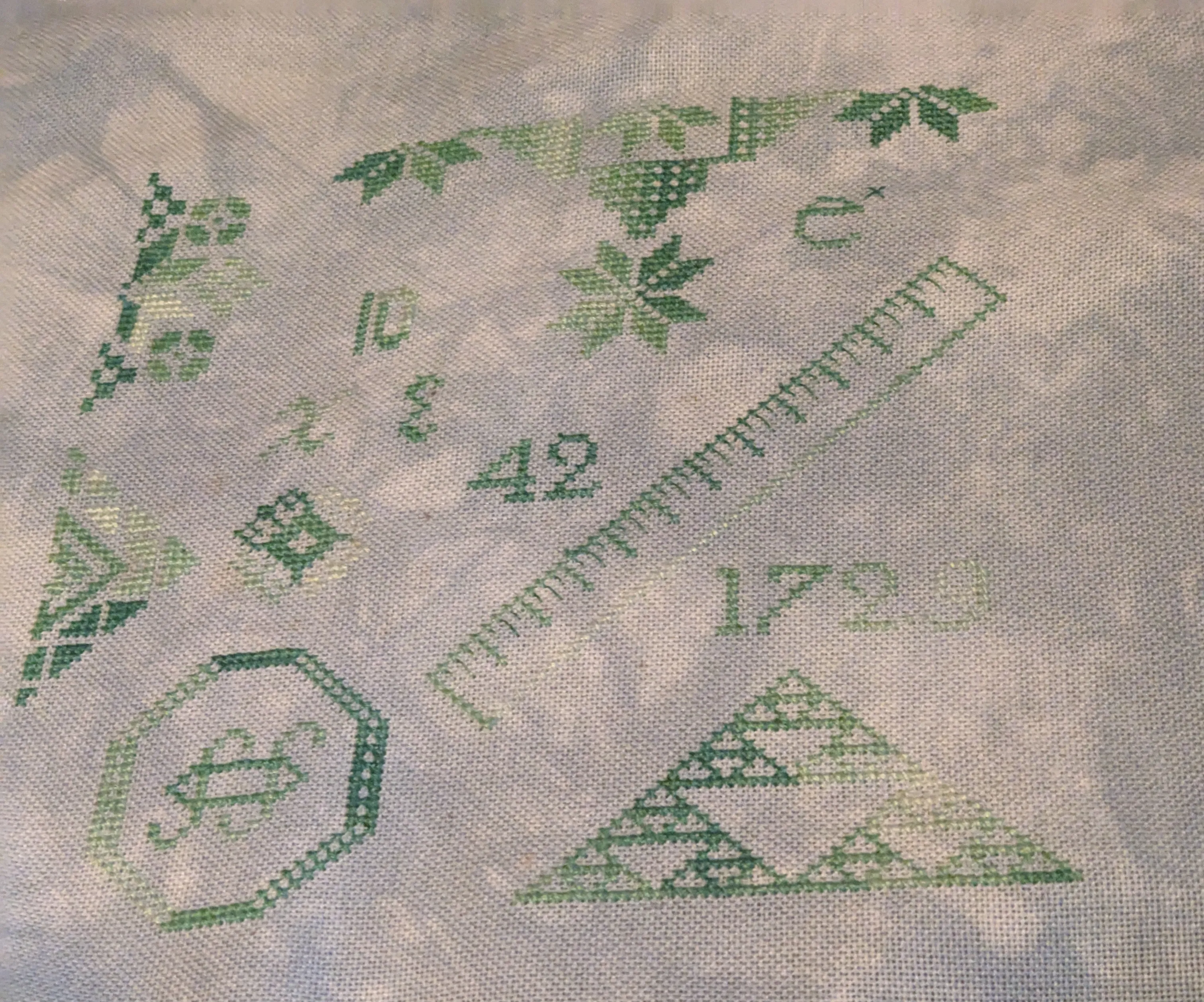 Image of a math themed Quaker sampler in shades of green