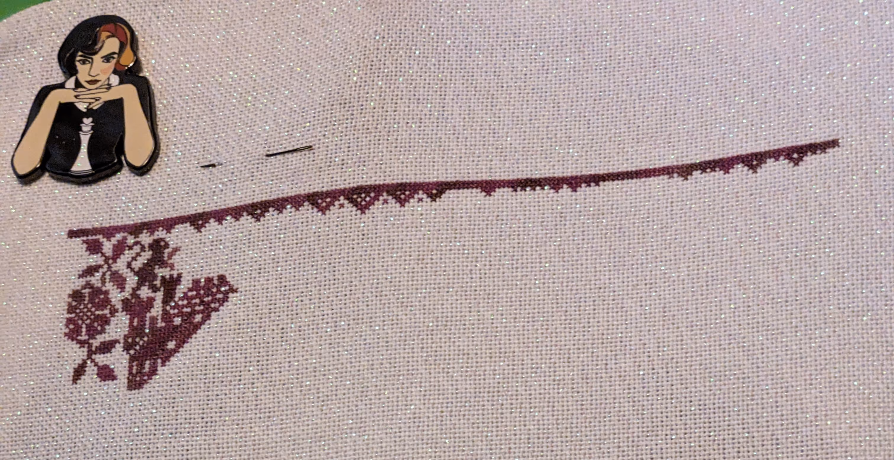 A fanciful cross stitch pattern with flowers, castles, and chess pieces