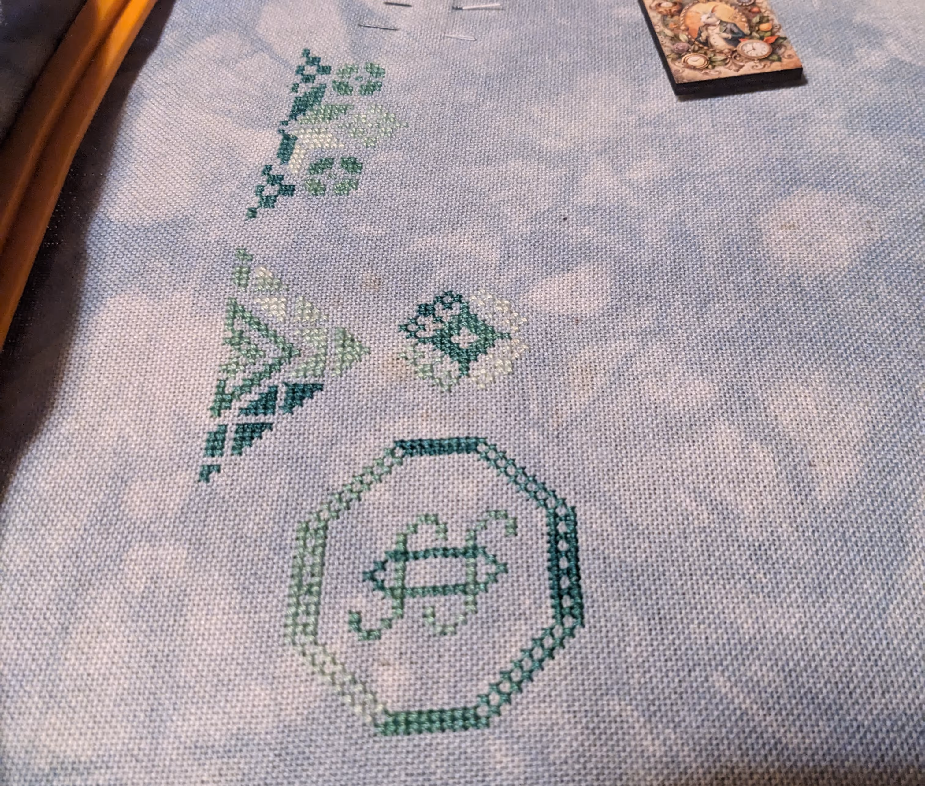 A cross stitch of a Quaker sampler with a math theme in shades of green