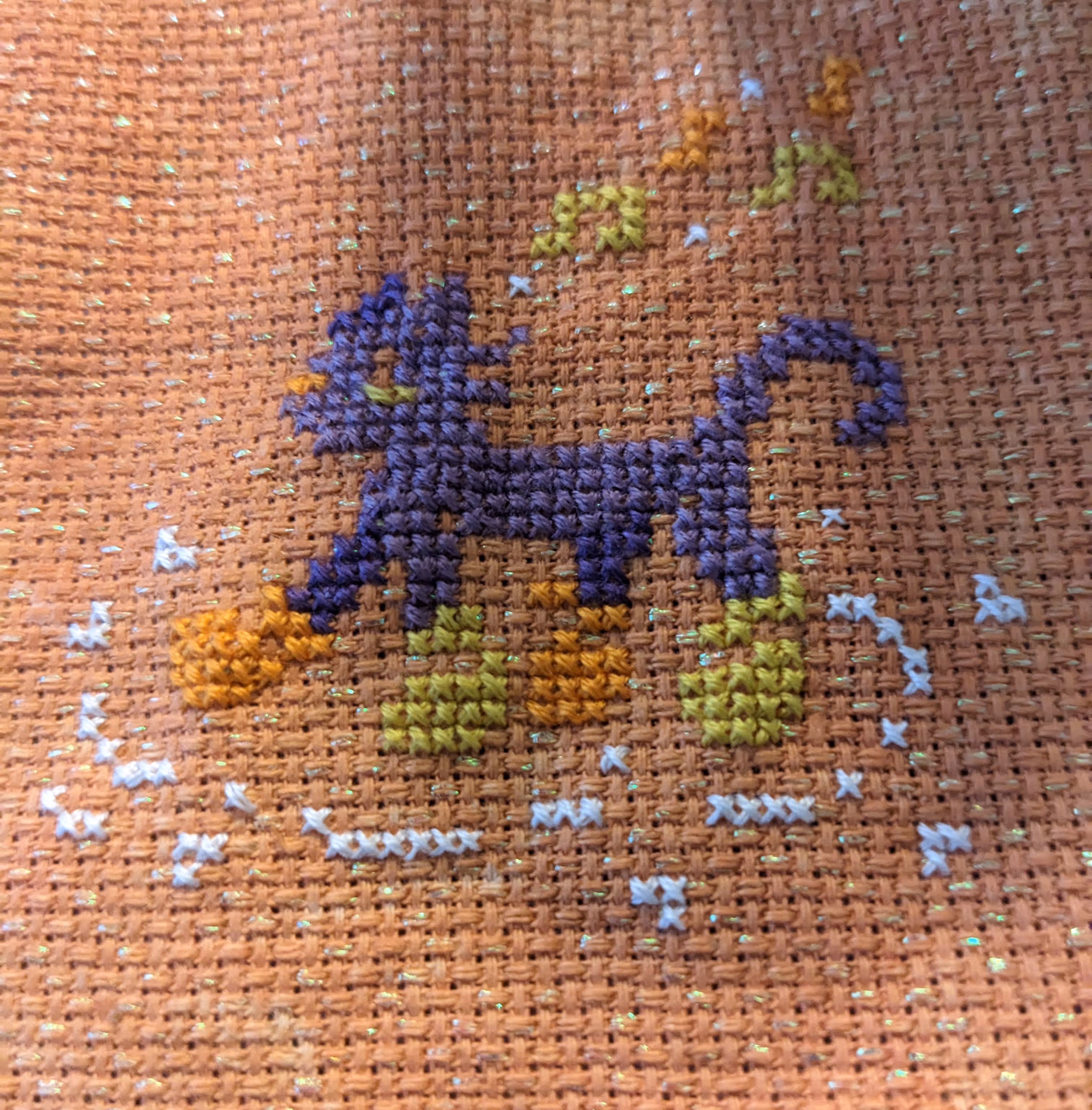 A purple cate in oversized orange and yellow rain boots sings while splashing in a puddle