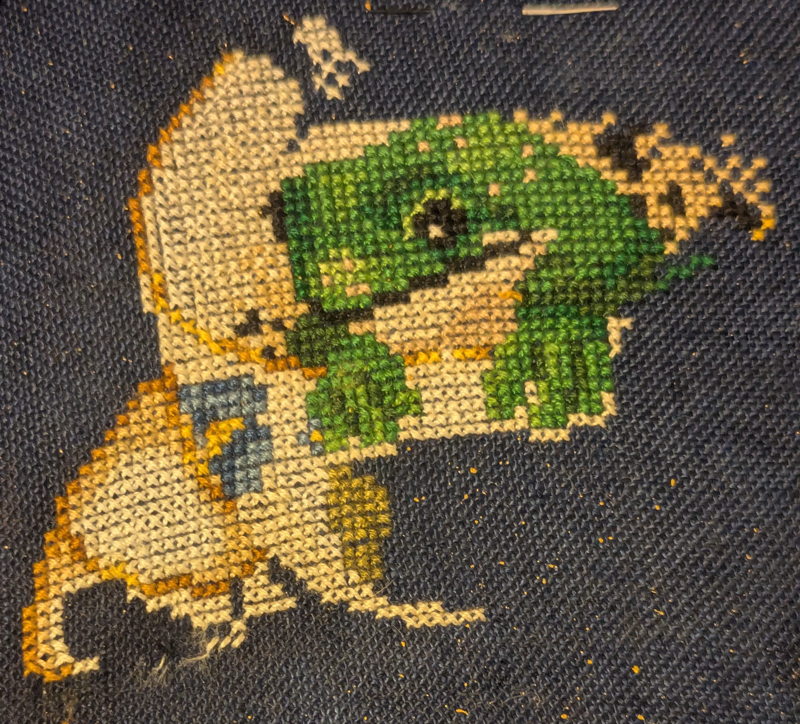 A frog peers out of a tea cup with gold gilded edges