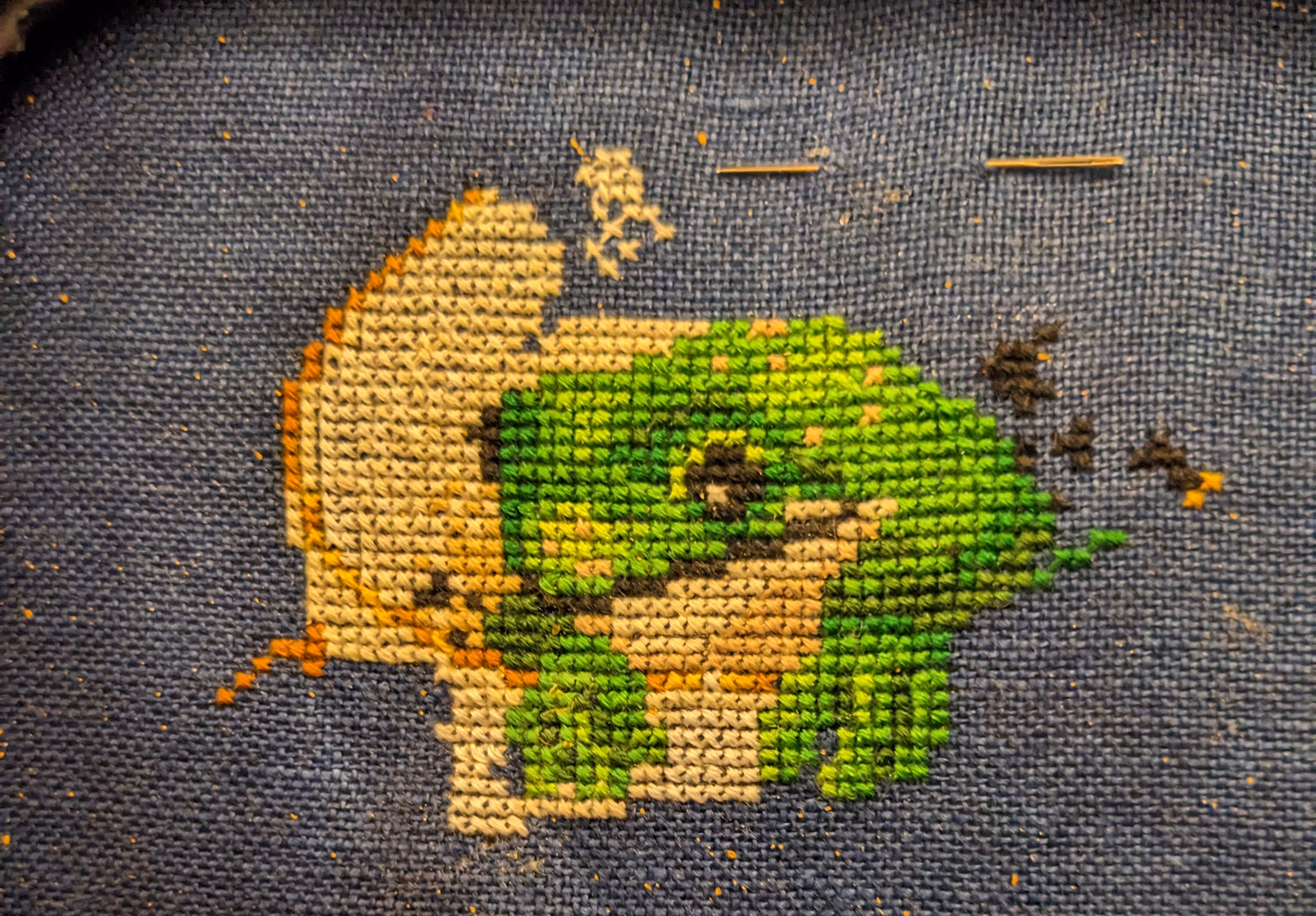 A lovely green frog sits in a tea cup with gold edges and raising steam