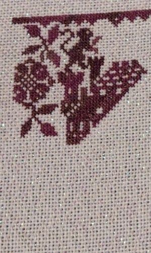 The beginning of a castle from a chess themed sampler in red floss