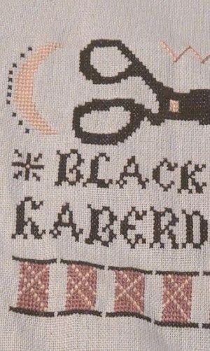 Two blackbirds are featured beside text that says black wing haberdashery there are spools of pink thread on the bottom of the project a sun and moon at the top along with threaded needles