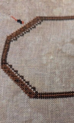 The start of a red dragon fly and a frame in shades of brown with no back stitch
