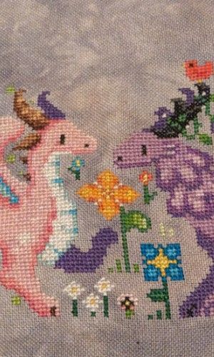 The faces of two flowered inspired dragons where one is pink and white and the other is in shades of purple