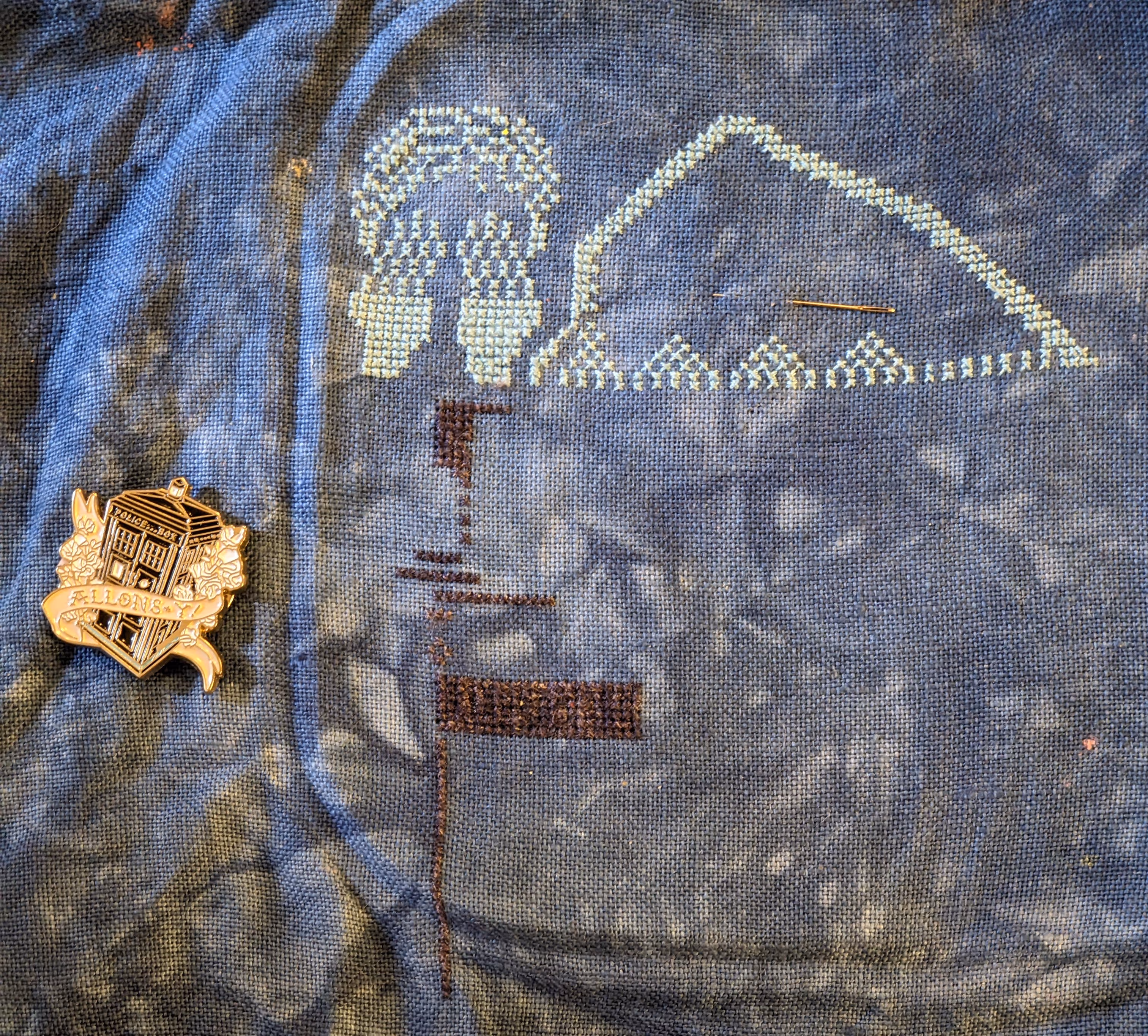 Image of a cross stitch featuring the Tardis, a Weeping Angel, roses, Daleks, and Cybermen from Doctor Who